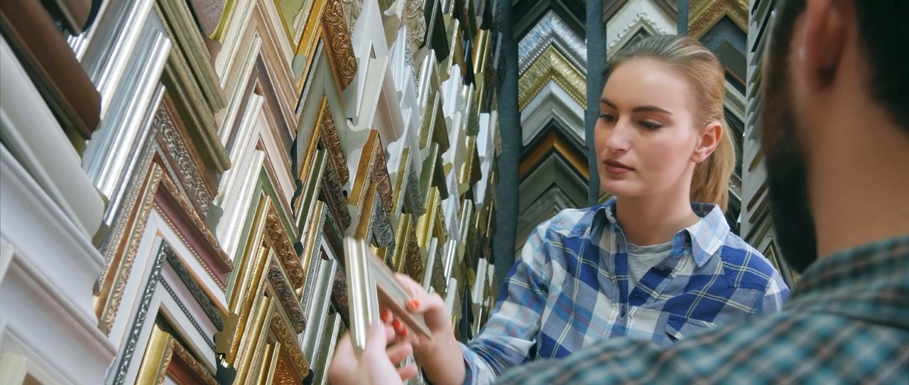 Woman looking at picture frame samples.